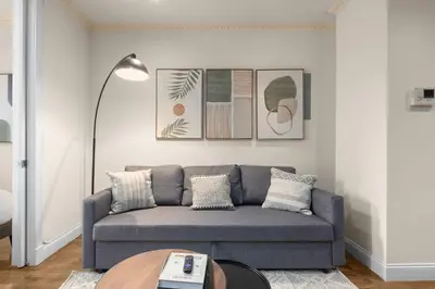 a living room with a couch and a table at Stylish East Side Escape Steps from Fun in New York