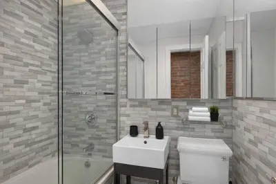 a bathroom with a sink and a shower and a toilet at Stylish East Side Escape Steps from Fun in New York