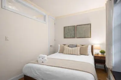 a bedroom with a white bed with two towels on it at Stylish East Side Escape Steps from Fun in New York