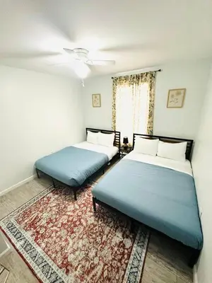 two beds in a room with a rug at Explore Poconos with Fire pit, Games, Grill in Tobyhanna