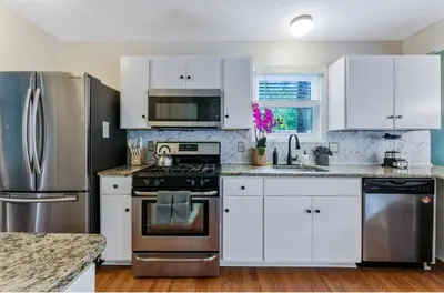 a kitchen with white cabinets and stainless steel appliances at Dine Outdoors, Dream Indoors 5BR in East Stroudsburg