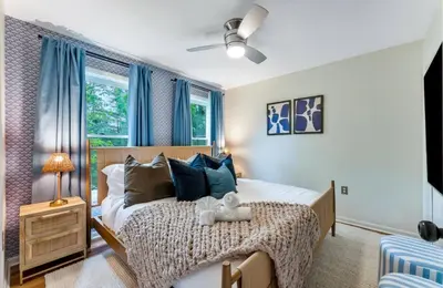 a bedroom with a large bed with blue curtains at Dine Outdoors, Dream Indoors 5BR in East Stroudsburg