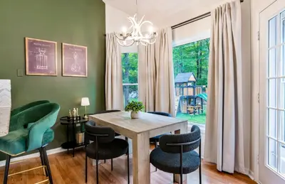 a dining room with green walls and a wooden table and chairs at Dine Outdoors, Dream Indoors 5BR in East Stroudsburg