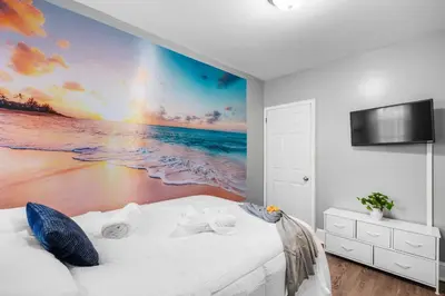 a bedroom with a white bed and a beach at Bright Corner Flat near Transit and Trails in Philadelphia