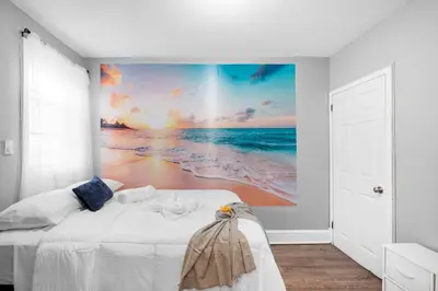 a bedroom with a beach mural on the wall at Bright Corner Flat near Transit and Trails in Philadelphia