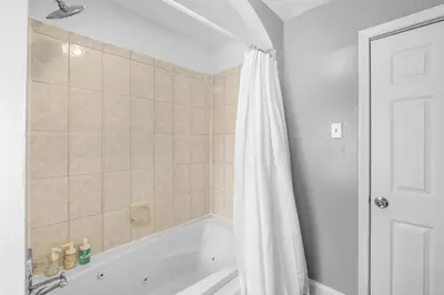 a bath tub with a shower curtain in a bathroom at Bright Corner Flat near Transit and Trails in Philadelphia