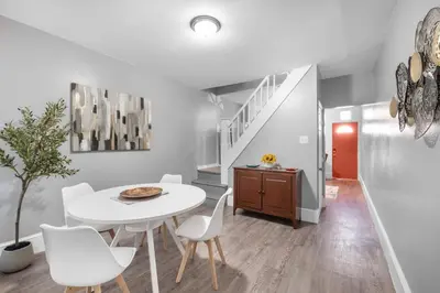 a white dining room with a white table and white chairs at Bright Corner Flat near Transit and Trails in Philadelphia
