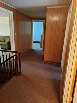 a hallway with a staircase and a room with a door at The Canton House