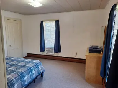 a bedroom with a bed and a window with blue curtains at The Canton House