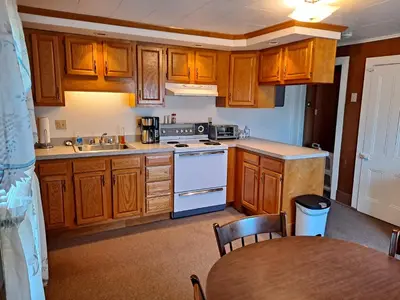 a small kitchen with wooden cabinets and a table at The Canton House