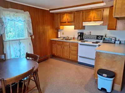 a kitchen with wooden cabinets and a table and a stove at The Canton House