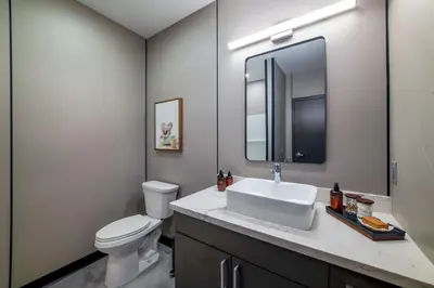 a bathroom with a sink and a toilet and a mirror at 4505 Lofts in Vestal