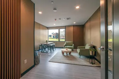 a lobby with a waiting room with chairs and a table at 4505 Lofts in Vestal