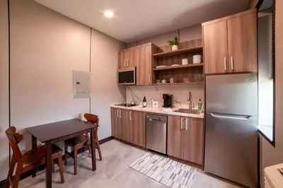 a kitchen with a table and a stainless steel refrigerator at 4505 Lofts in Vestal