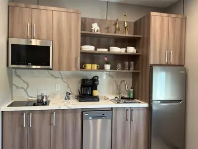 a kitchen with wooden cabinets and a stainless steel refrigerator at 4505 Lofts in Vestal