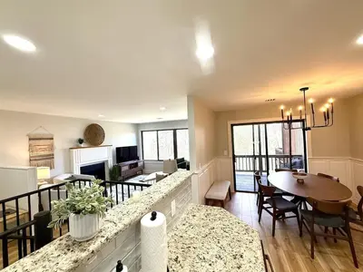 a kitchen and living room with a dining room and a table at The Canopy 4BR Forest Escape Spa, Sip, and Unwind in Vernon Township