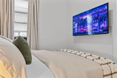a living room with a couch and a flat screen tv at Style & Comfort 3 Rooms -15 min from NYC in West New York