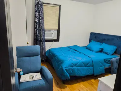 a bedroom with a blue bed and a chair at Log Comfort in Newark