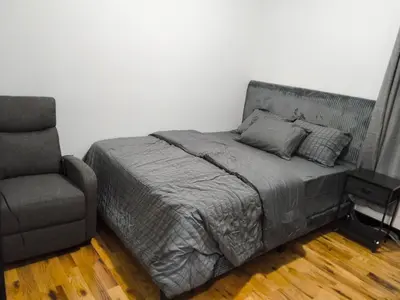a bed and a chair in a room with a bed and a couch at Log Comfort in Newark