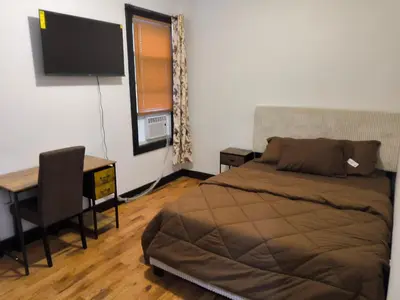 a bedroom with a bed and a desk and a television at Log Comfort in Newark