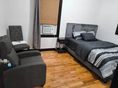 a bedroom with a bed and a couch and a chair at Log Comfort in Newark