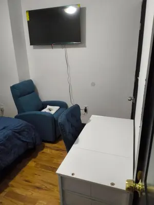 a room with a tv and a couch and a chair at Log Comfort in Newark