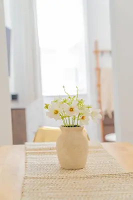 a vase filled with white flowers sitting on a table at Moderno y Céntrico Estacionamiento Privado A 15 min de NYC in Jersey City