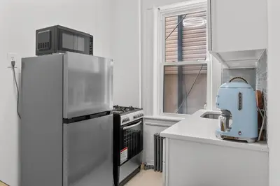 a kitchen with a refrigerator and a stove at Moderno y Céntrico Estacionamiento Privado A 15 min de NYC in Jersey City