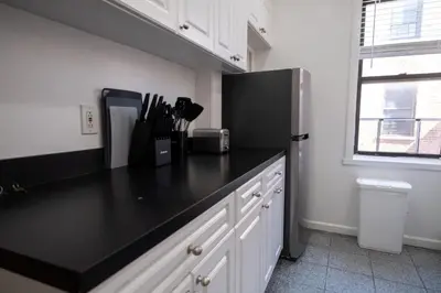 a kitchen with a black counter top and a refrigerator at Sunny 4BR/2BA Retreat in Morningside Heights, NYC in New York