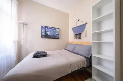 a small bedroom with a bed and shelves at Sunny 4BR/2BA Retreat in Morningside Heights, NYC in New York
