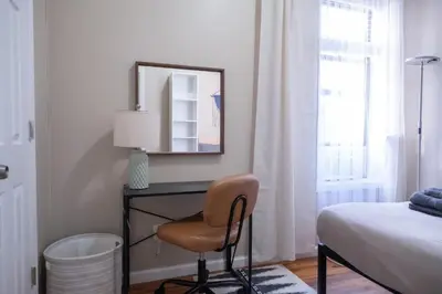 a bedroom with a desk with a chair and a mirror at Sunny 4BR/2BA Retreat in Morningside Heights, NYC in New York