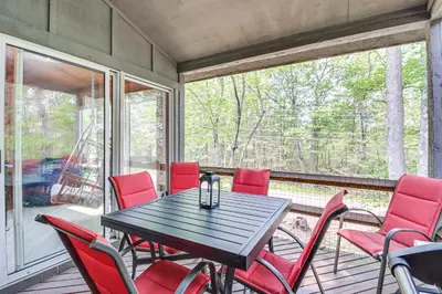 a dining room with a table and red chairs on a porch at Steps to Jack Frost Ski Resort Townhome with Decks in Lake Harmony