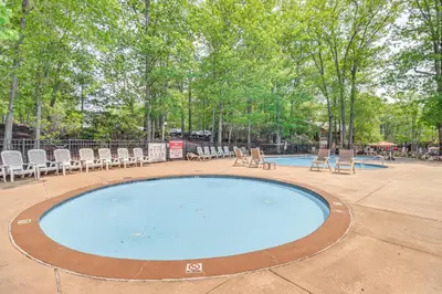 a large swimming pool with chairs and trees at Steps to Jack Frost Ski Resort Townhome with Decks in Lake Harmony