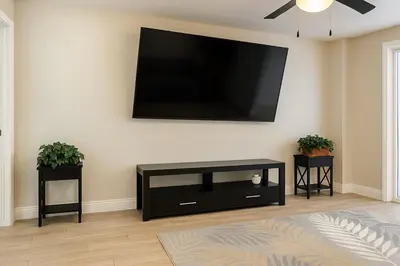 a living room with a flat screen tv on a wall at Group-Friendly Luxury 3BR 2 Baths Sleeps 8 in Irvington