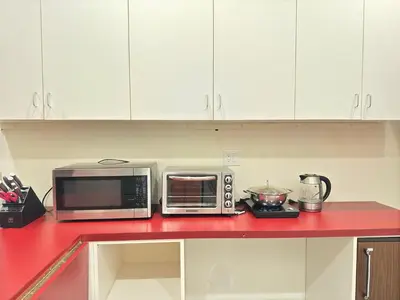 a kitchen with two microwaves on a red counter top at Zen House in Princeton