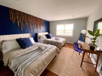 a bedroom with two beds and a blue wall at Easy PATH&Bus access- NYC designer home & Terrace in Jersey City