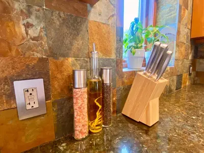 two bottles of oil on a counter next to a light switch at Comfortable home close to Manhattan,Wall St & more in Jersey City