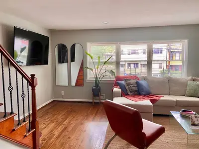 a living room with a couch and a table at Comfortable home close to Manhattan,Wall St & more in Jersey City
