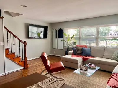 a living room with a couch and a table at Comfortable home close to Manhattan,Wall St & more in Jersey City