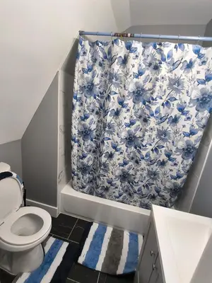 a bathroom with a toilet and a shower curtain at Log Comfort 2 in Newark
