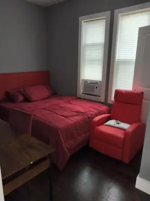a bedroom with a red bed and a red chair at Log Comfort 2 in Newark