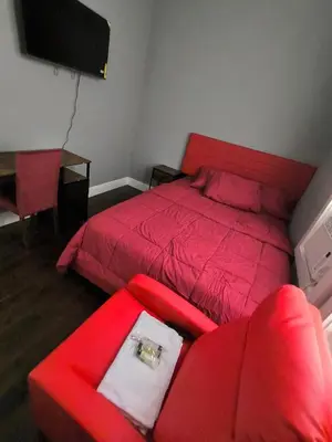 a bedroom with a red bed and a red chair at Log Comfort 2 in Newark