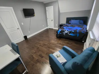 a living room with a bed and a blue couch at Log Comfort 2 in Newark