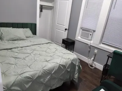a bedroom with a bed and a window with a fan at Log Comfort 2 in Newark