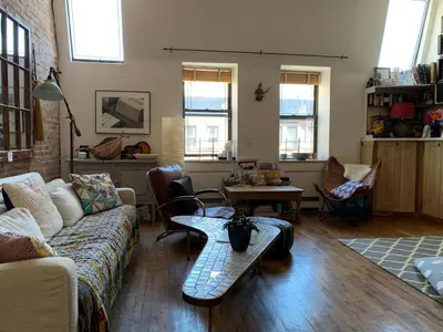 a living room with a couch and a table at Airy brownstone penthouse duplex near Central Park in New York