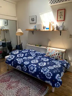 a bedroom with a bed with a blue and white blanket at Airy brownstone penthouse duplex near Central Park in New York