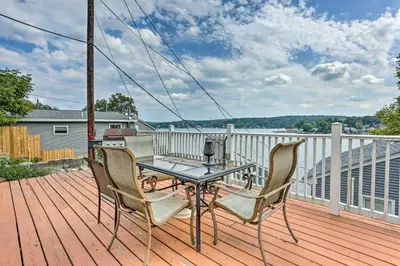 a patio with a table and chairs on a deck at Cozy Lakefront House with a private dock and lake in Hopatcong
