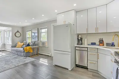 a kitchen with a white refrigerator and a couch at Cozy Lakefront House with a private dock and lake in Hopatcong
