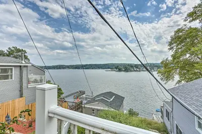 a view of a lake from the balcony of a house at Cozy Lakefront House with a private dock and lake in Hopatcong
