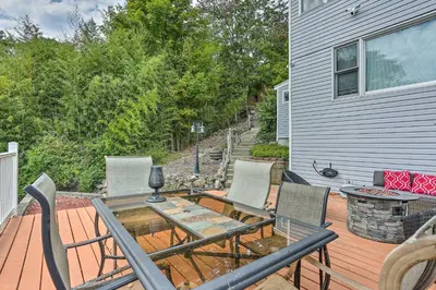 a patio with a table and chairs on a deck at Cozy Lakefront House with a private dock and lake in Hopatcong